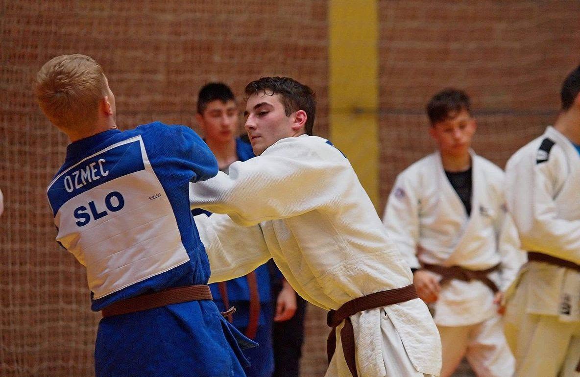 Dario Zavišić in a white judogi grips an opponent.